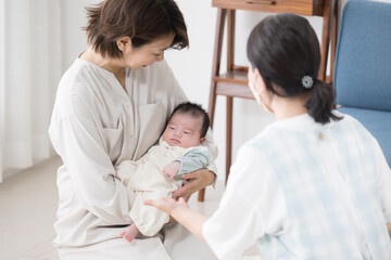新生児や乳幼児の1ヶ月訪問をうける母親 赤ちゃん訪問の様子