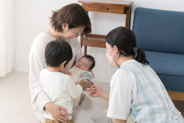 Obraz na płótnie Canvas 新生児や乳幼児の1ヶ月訪問をうける母親 赤ちゃん訪問の様子 2人兄弟