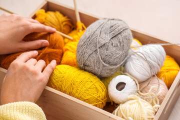 Fototapeta na wymiar Young woman with knitting yarn at home, closeup