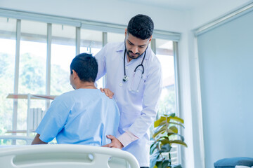 Obraz premium Doctor physiotherapist treating lower back pain patient after while giving exercising treatment on stretching in the hospital, Rehabilitation physiotherapy concept.