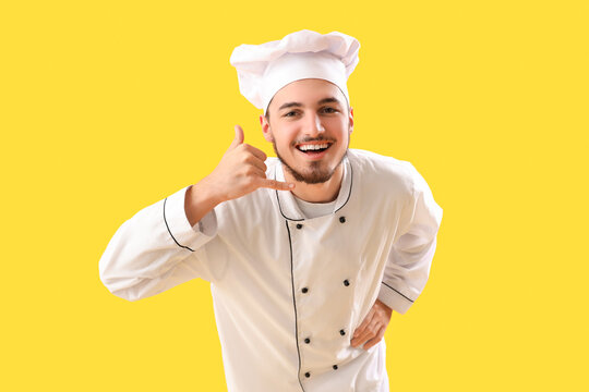 Male chef showing "call me" gesture on yellow background