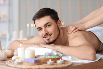 Obraz na płótnie Canvas Young man getting massage in spa salon, closeup
