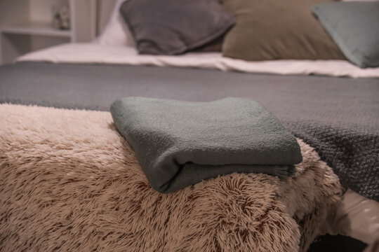 Soft blankets on bench in bedroom at night, closeup