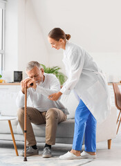 Nurse helping senior man to stand up at home