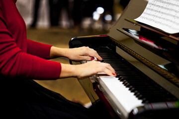 Pianist playing a grand piano. Close up of female hands playing the piano.