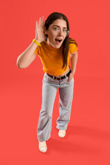 Young gossip woman trying to hear something on red background