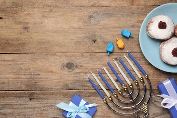 Flat lay composition with Hanukkah menorah and gift boxes on wooden table. Space for text