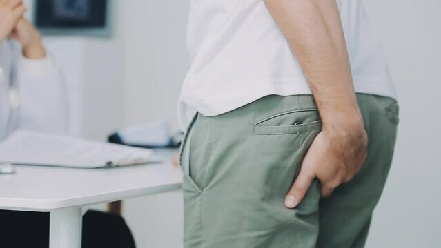 Doctor prescribes treatment to patient with bowel problems and model of unhealthy lower rectum