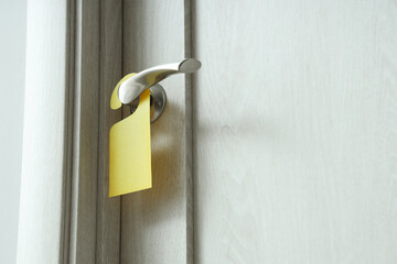Wooden door with hanger in hotel room, closeup