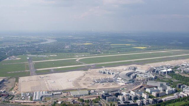 High resolution video from D&uuml;sseldorf International Airport, taken from a helicopter. It shows the airport including the runway. It pans from the sky to the airport.
