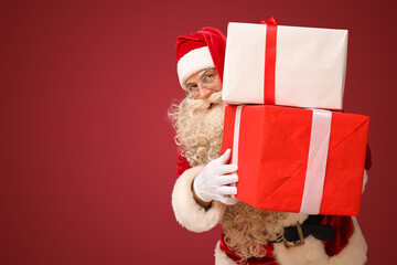 Santa Claus with Christmas gifts on red background