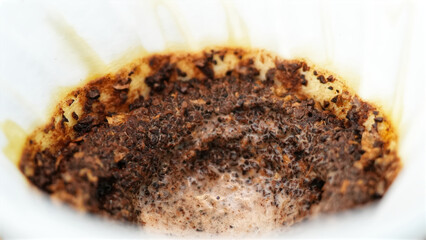 Close up of coffee drip filter after Barista pouring hot water on ground coffee.