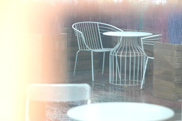Table and chair outdoor Cafe, looking through window.