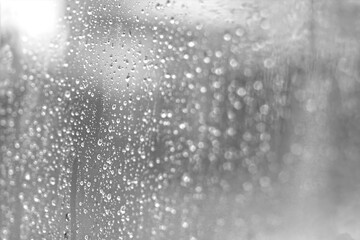 Raindrop on glass looking through window.