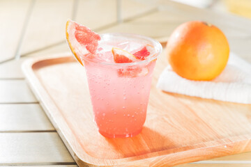 pink grapefruit soda on wood background - soft focus with vintage film filter