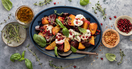 Roasted beets with burrata cheese topped with herbs and pomegranate arils.