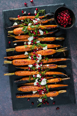 Roasted carrots topped with goat cheese, herbs and pomegranate arils.