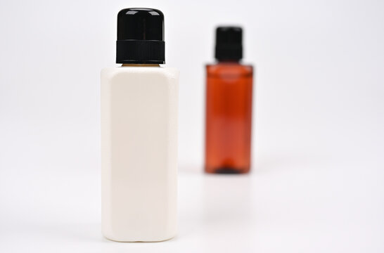 白いボトルの背後に茶色のボトル