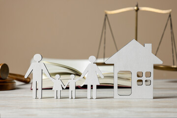 Family law. Figures of parents with children, house, book, scales of justice and gavel on wooden...