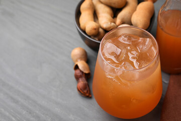 Freshly made tamarind juice on grey wooden table, closeup. Space for text