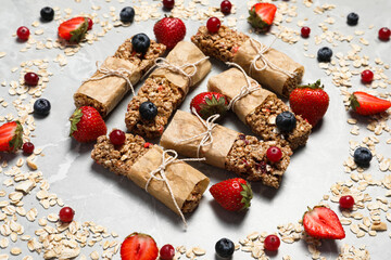 Tasty granola bars and ingredients on light grey marble table