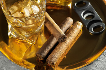 Tray with whiskey, cigars and cutter on grey table, closeup