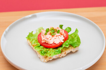 Rice Cake Sandwich with Tomato, Lettuce, Fish Cream and Green Onions on White Plate. Easy...