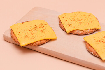 Crispy Cracker Sandwiches with Cheese and Paprika on Wooden Cutting Board and Beige Background