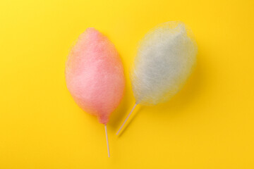 Fototapeta na wymiar Sweet color cotton candies on yellow background, flat lay