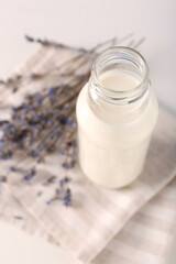 Bottle of tasty milk on light table, above view