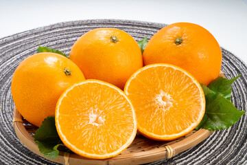 Fresh Orange fruit on wooden basket on white background, Japanese Ehime Orange with slices on White Background.