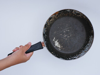 hand holding old used metal frying pan, isolated on white