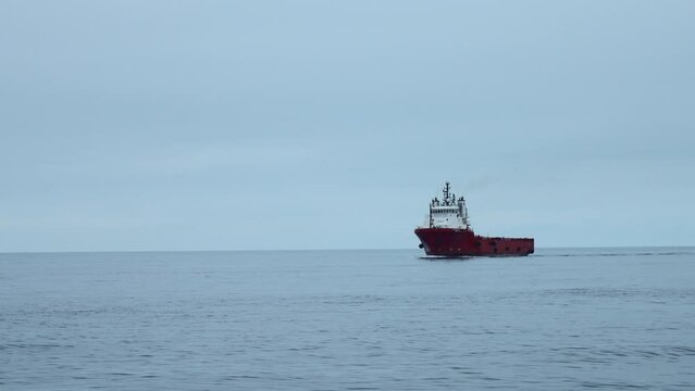 Floating ferry on background of cloudy sea horizon. Clip. Beautiful landscape with ferry in open sea. Ship on cruise in ocean in calm cloudy weather
