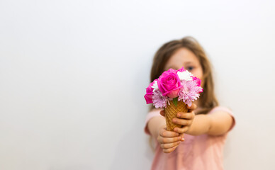 A little girl holding a flower ice cream 