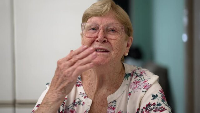 Elderly Senior Woman Waving Hello To Camera Talking In Video Webcam POV With Family Member