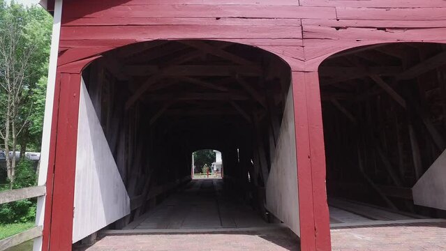 Roberts covered bridge in Eaton Ohio. Walking gimbal shot into one of the portals that reveals the timber construction inside. Arches and diagonal braces are visible.