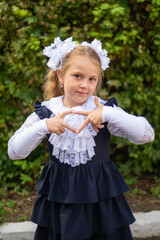 The first time in the first class! A first-grader girl in a beautiful elegant modern school uniform on the Day of Knowledge at school.