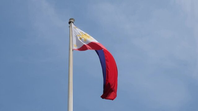 Philippine flag waving in the air with the blue skies as it background, inside the Philippine embassy in Bangkok, Thailand.