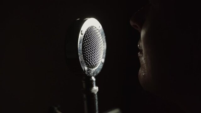 hate speech concept - very angry screaming in a microphone in the dark