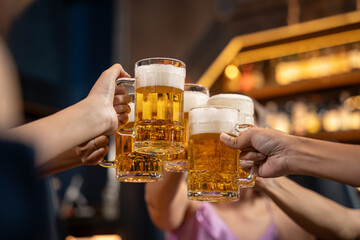 Close-up Group of People Holding Beer and Cheer in Restaurant. They Enjoying with Night Party...