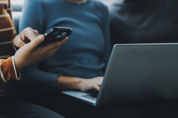 Asian Business woman using calculator and laptop for doing math finance on an office desk, tax, report, accounting, statistics, and analytical research concept