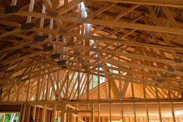 The wooden rafters above the future living area at a new home construction building site.