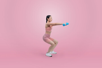 Fototapeta na wymiar Vigorous energetic woman doing dumbbell weight lifting exercise on isolated background. Young athletic asian woman strength and endurance training session as body workout routine.