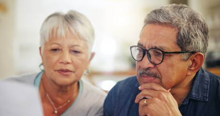 Senior couple, bills and reading documents in home for budget, planning financial assets and...