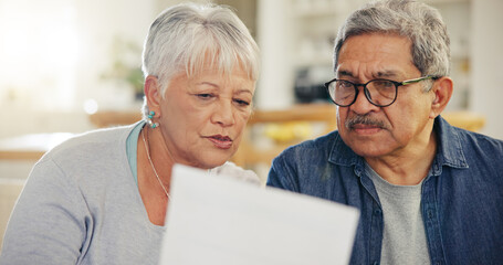 Senior couple, bills and reading paperwork in home for budget, planning investment and financial...