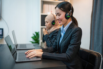 Friendly smiling woman call center operator with headset using computer, Customer service, Call center worker accompanied by her team at office.