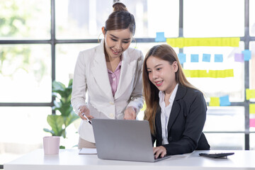 Team of confident asian business women point to graphs and charts to analyze market data, balance sheet, account, net profit to plan new sales strategies to increase production capacity.	