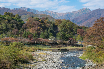 Fototapeta na wymiar 紅葉が進んだ諏訪峡から眺める谷川連峰