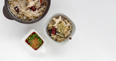 Korean food. Oyster hot stone pot rice with mushroom, jujube, sliced radish and soy sauce. Isolated on white background. Top view.
