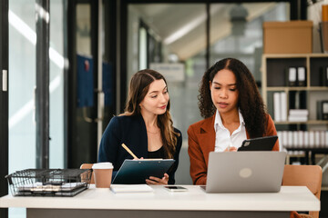 Two professional caucasian with african american businesswoman friends collaboration, working together at office, using laptop, Generally accepted audit standards, Earnings before interest and taxes